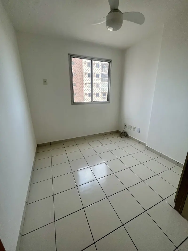 Quarto com ventilador de teto e janela com vista livre