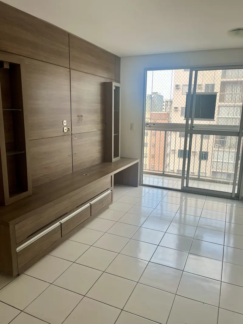 Sala de estar com painel planejado e acesso à varanda